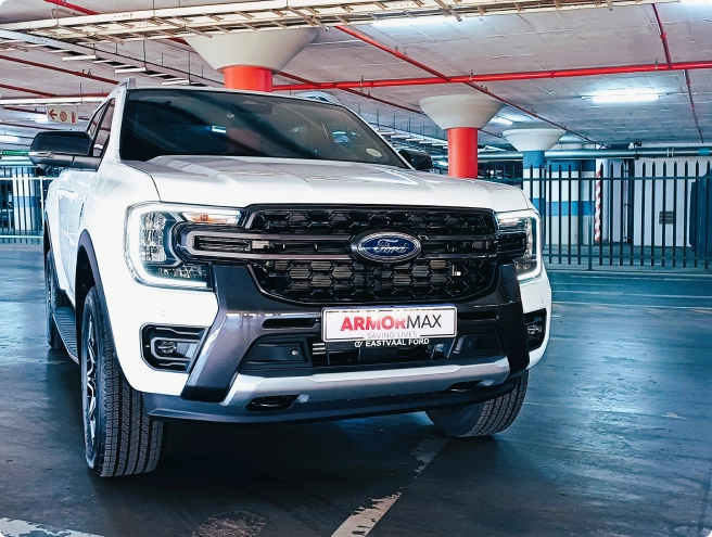 A white Ford Ranger pickup truck with "ARMORMAX" and "EASTVAAL FORD" branding is parked in an underground garage.