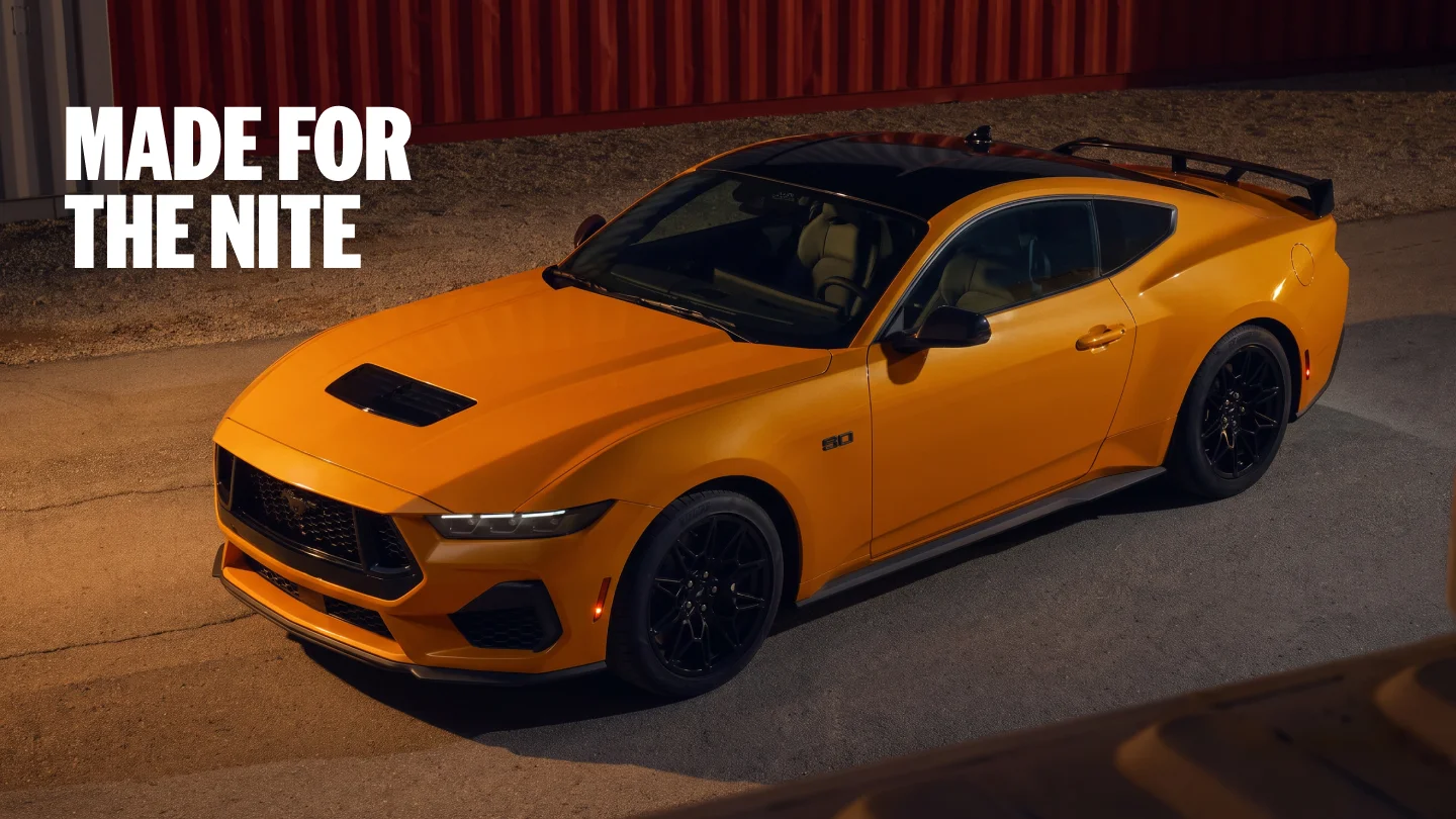 Yellow Ford Mustang GT coupe parked at night