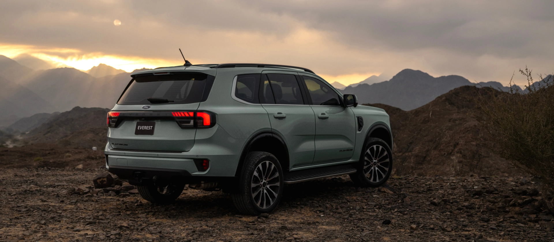 Ford Everest Platinum in Aluminium Metallic shown on rugged mountain terrain at sunset