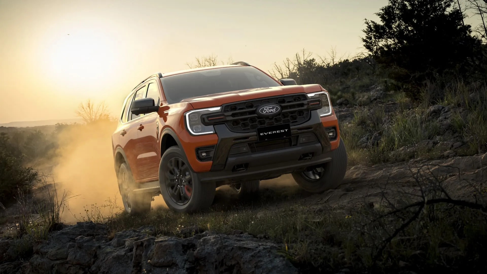 Orange Ford Everest SUV navigating a dusty rocky trail