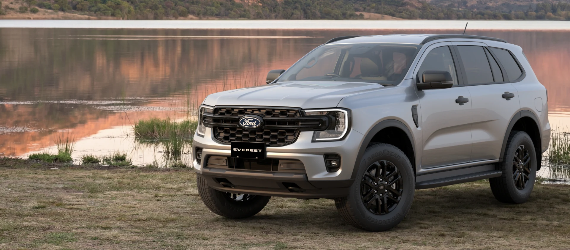 Silver Ford Everest SUV parked beside a calm lake