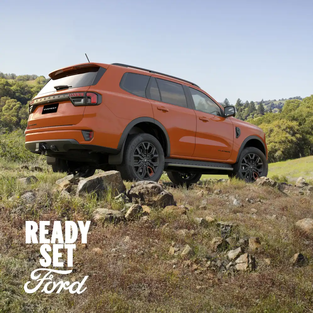 Orange Ford Everest positioned on a rocky hillside