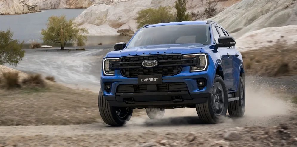 Blue Ford Everest SUV driving on a dusty off-road track