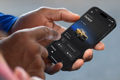 Person using Ford mobile app on smartphone.