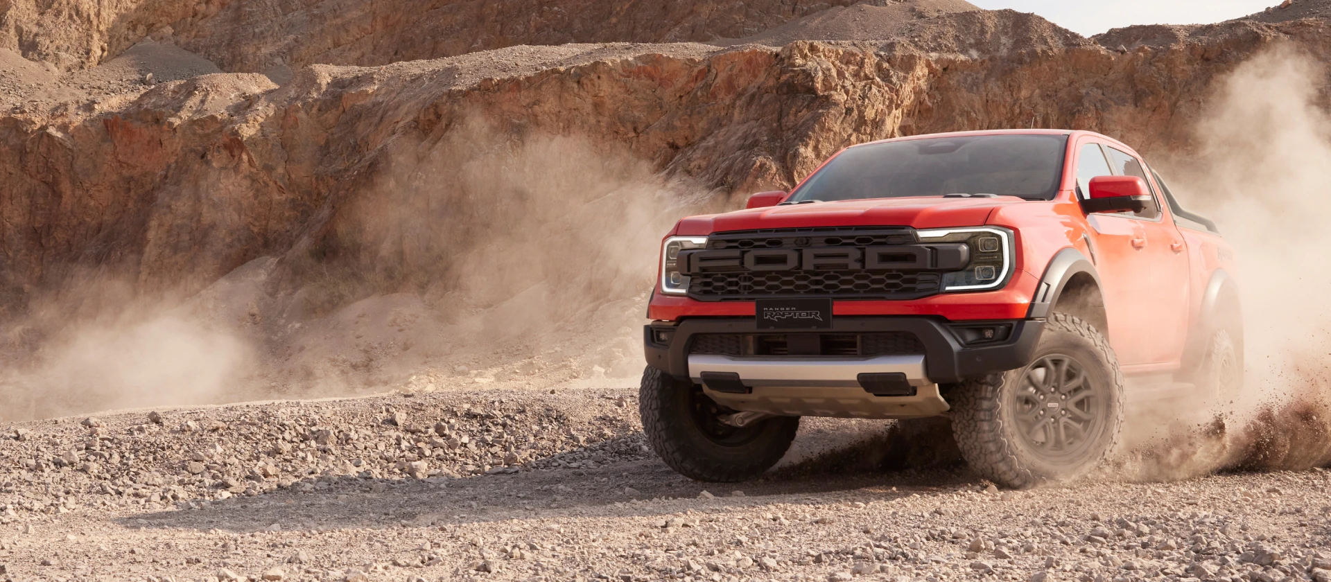 Front View of Raptor on a Sandy Terrain in Code Orange Color