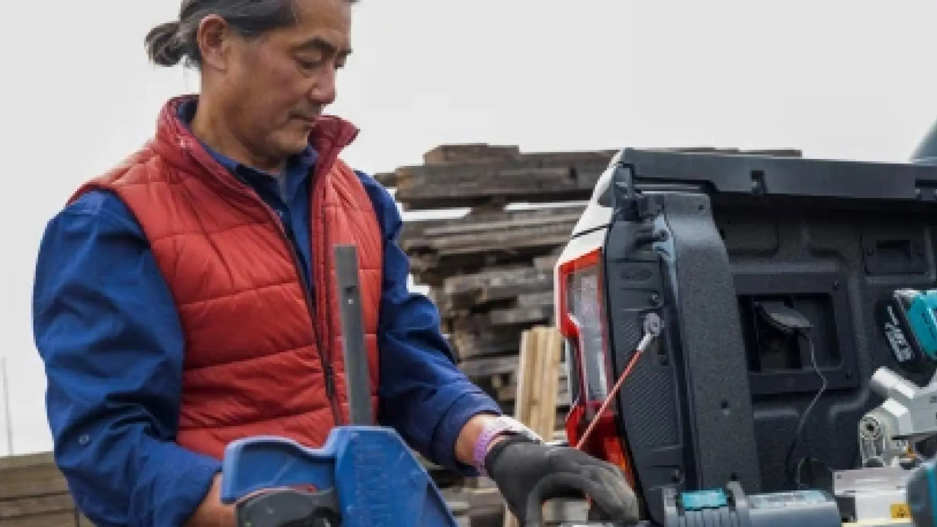 worker loading equipment into pickup truck bed