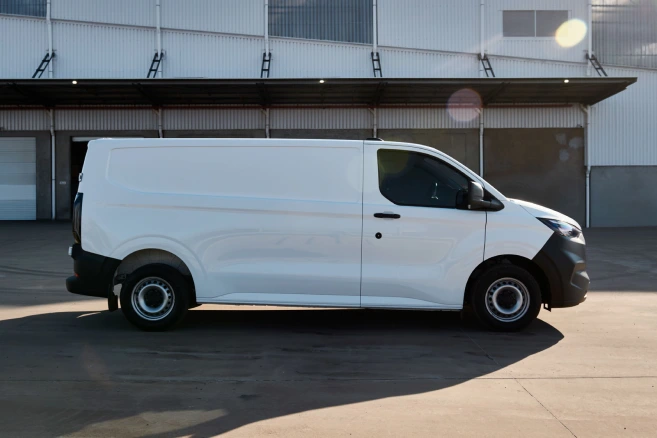 Side profile of white Ford Transit van outside warehouse